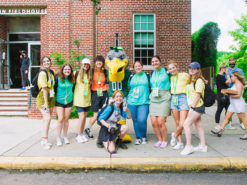 A group of Wave Leaders poses with Riptide during New Student Orientation 2021